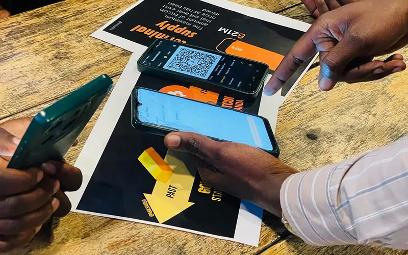 Community members exchanging Bitcoin notes at a market